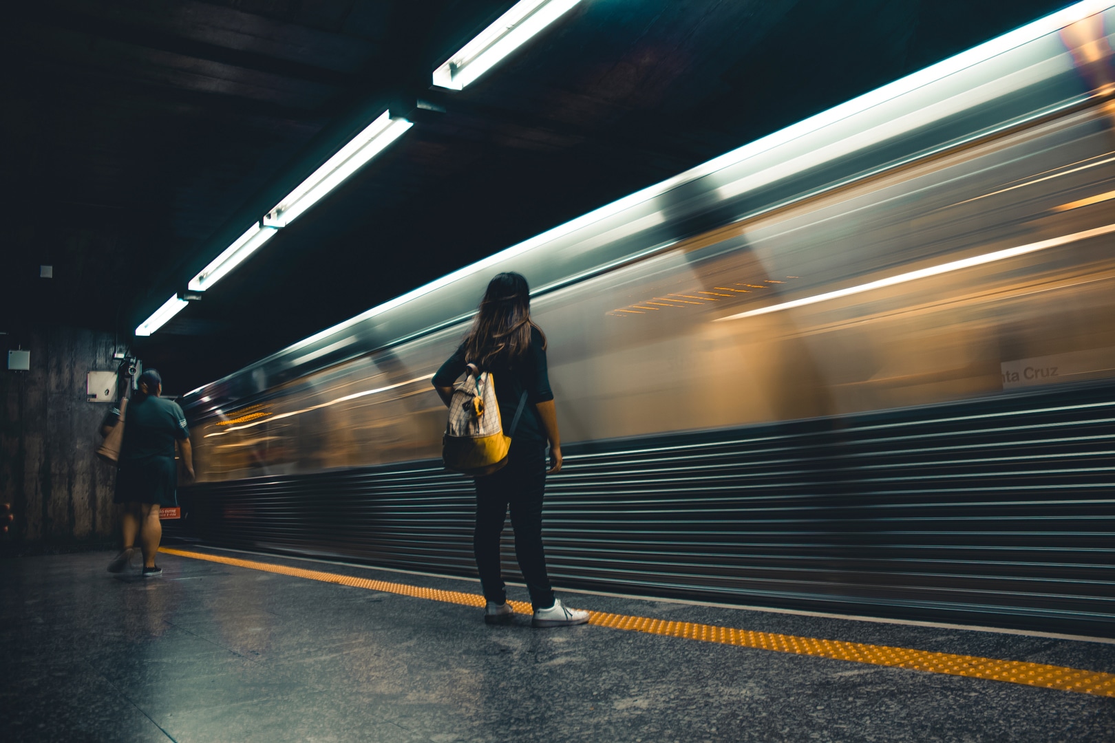 Woman Standing in Front of Speeding Subway Car