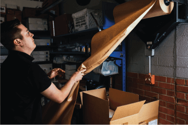 Man Tearing Paper to Package Items in Box